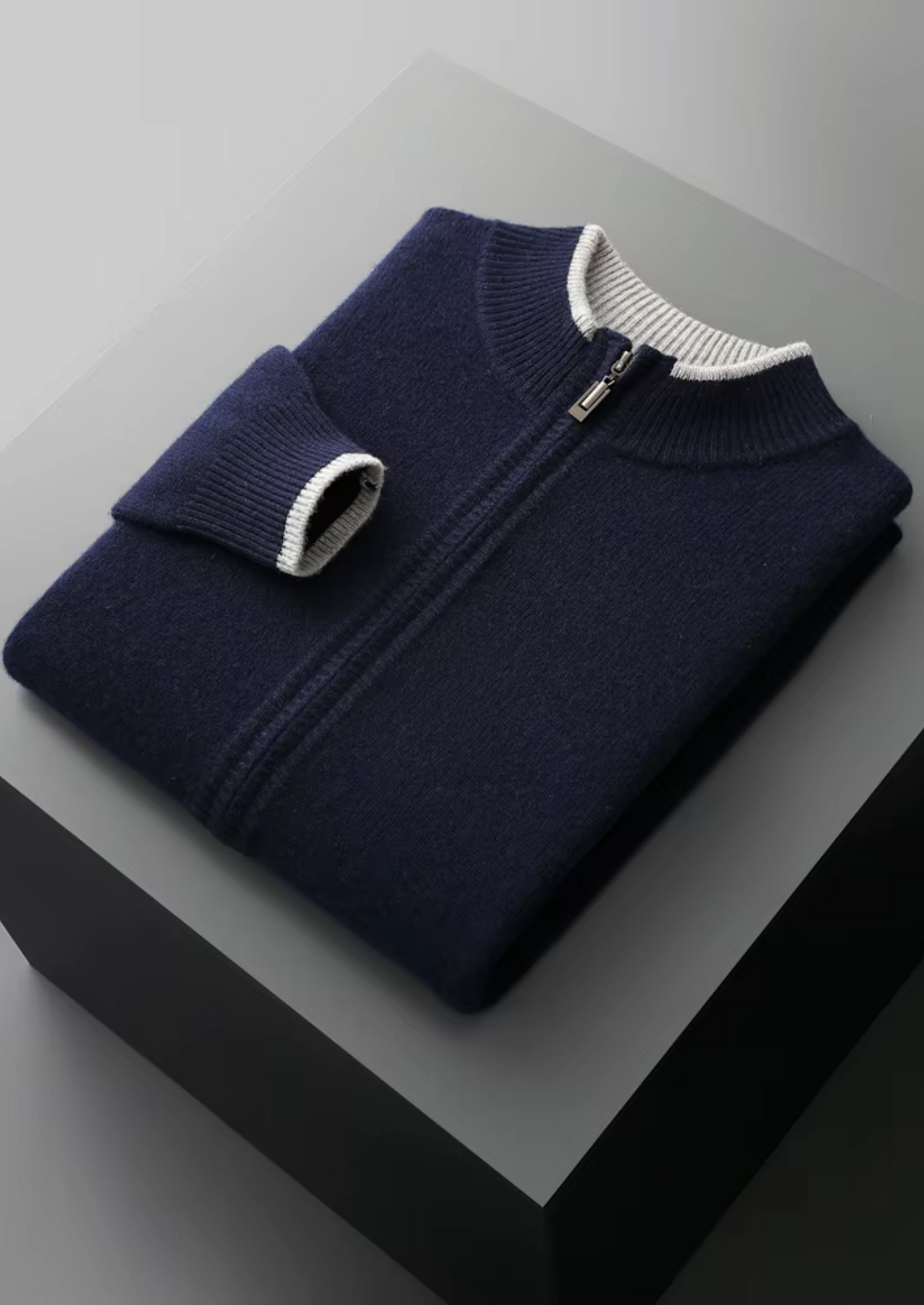 Man in de grijze cardigan met lichte achtergrond, focus op het gezicht en de comfortabele kraag.