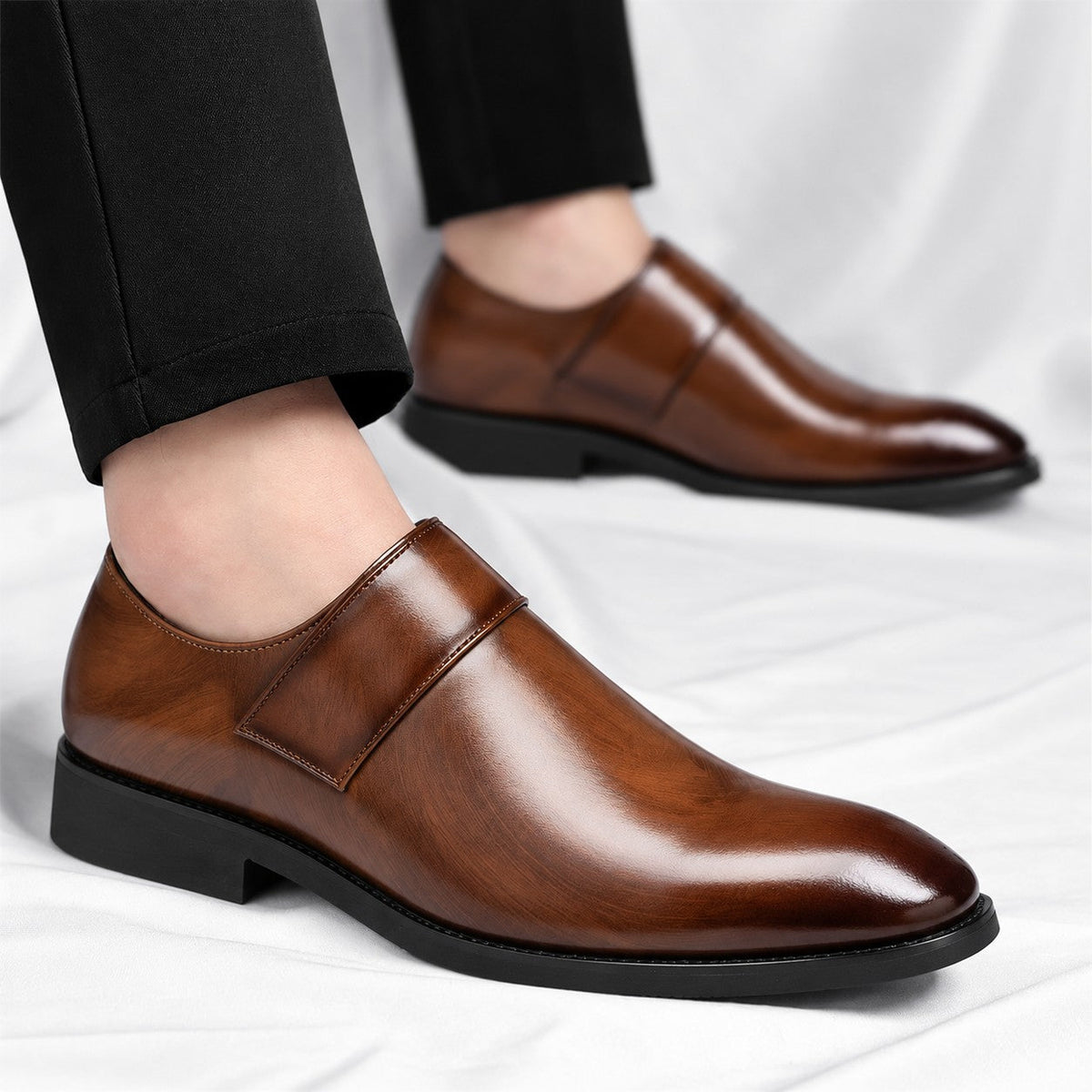 Zijprofiel van de zwarte leren loafers, tonend de slanke lijn en de stevige rubberen zool.