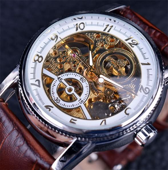 Close-up van het Marius automatische horloge met zilveren kast en witte skelet wijzerplaat, gedragen om een mannelijke pols.