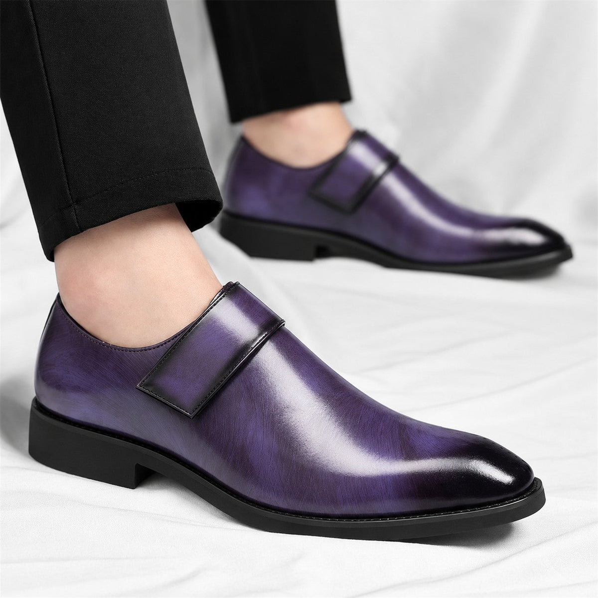 De drie beschikbare kleuren (bruin, paars, zwart) van de leren loafers naast elkaar gepresenteerd.