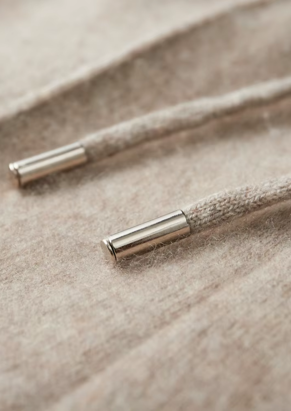 Detail van de zoom en de hoogwaardige kwaliteit van de donkergrijze Merino wollen sweater.