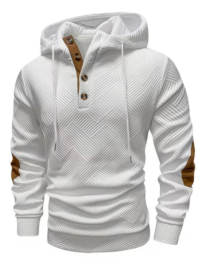 Mannelijk model in een casual setting, draagt de witte Jesper hoodie gecombineerd met jeans voor een frisse uitstraling.