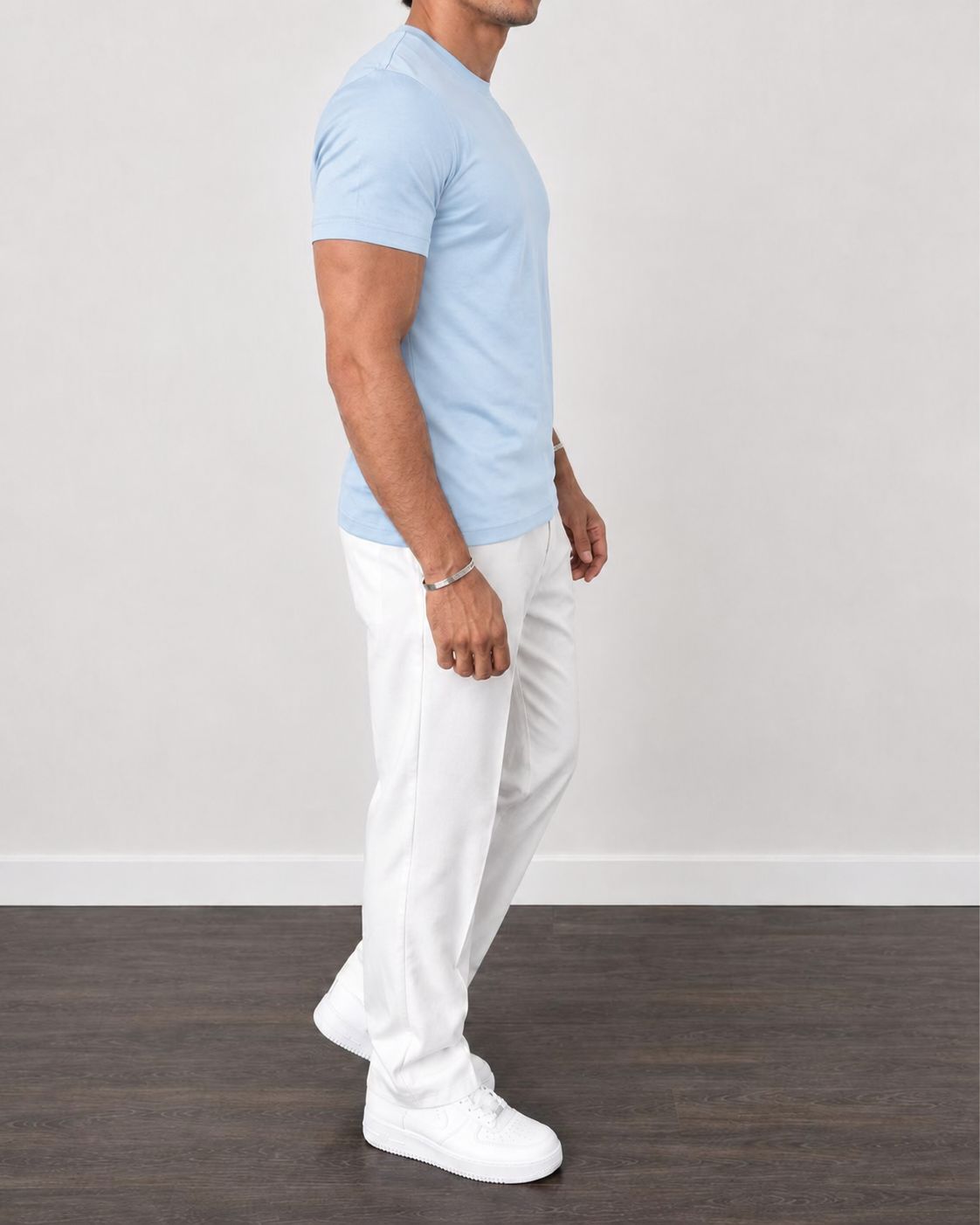 Zijaanzicht van een man in een donkerblauw Heren T-shirt, waarbij de comfortabele pasvorm rond de armen en borst zichtbaar is.