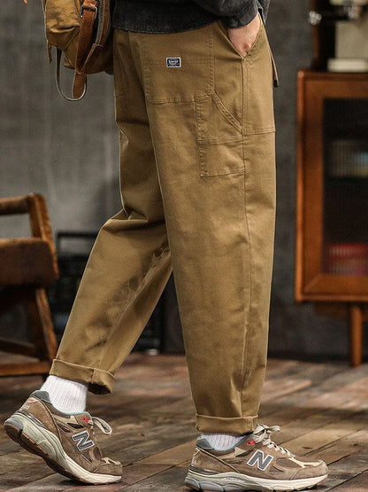 Model dat loopt in de legergroene utility broek, dynamisch shot dat de bewegingsvrijheid benadrukt.