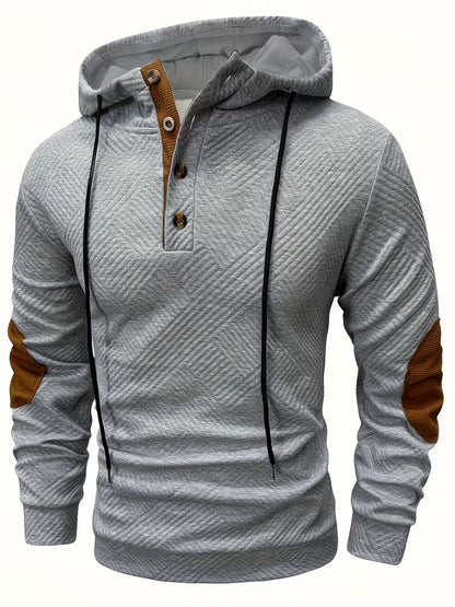Mannelijk model draagt de Jesper gestructureerde hoodie in grijs, frontaal met capuchon omlaag voor een casual look.