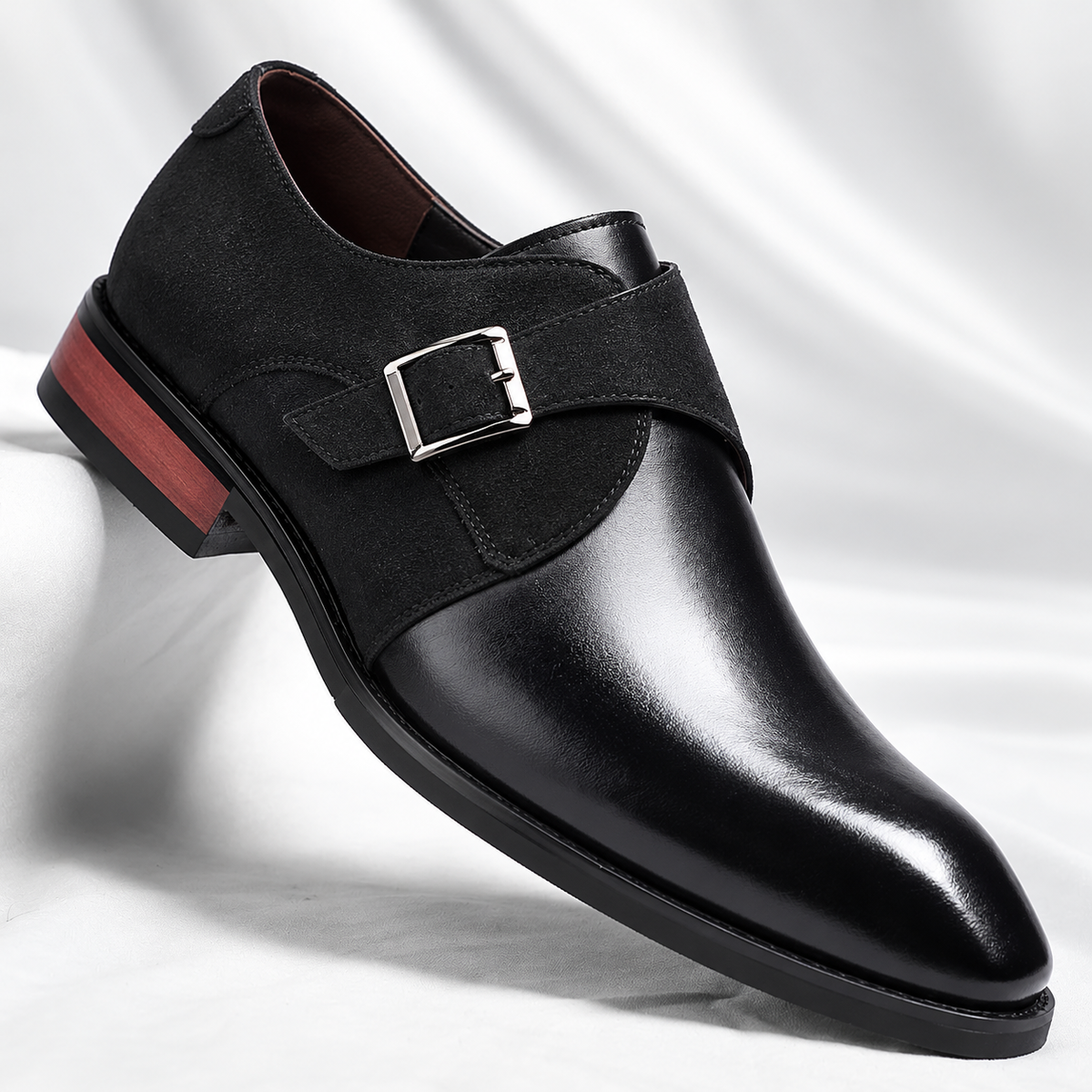 Een paar zwarte Kiran heren loafers elegant gepresenteerd op een houten vloer, klaar om gedragen te worden.
