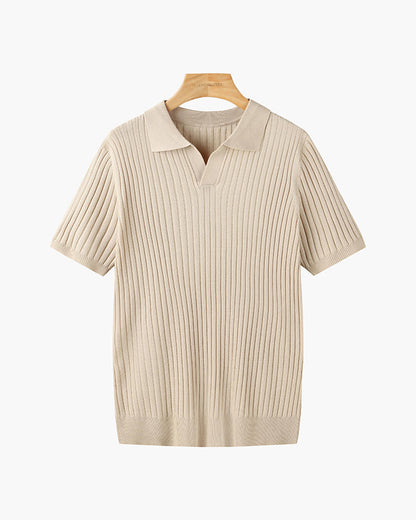 Wit geribbeld V-hals poloshirt, schuin van bovenaf gefotografeerd, met lichte schaduwen die diepte geven.