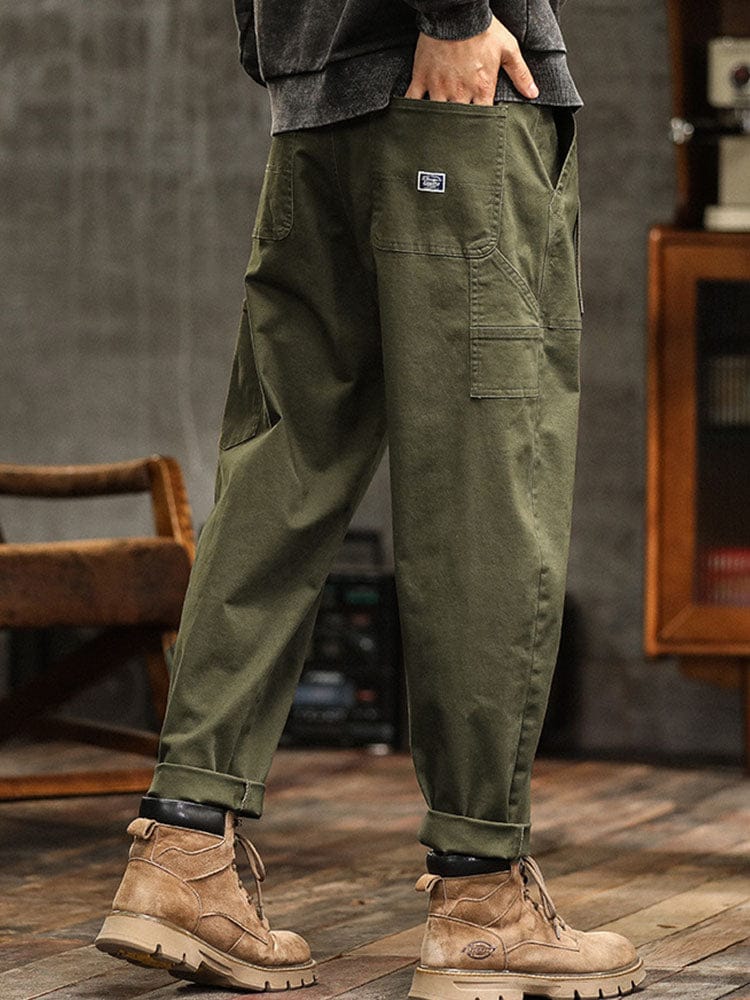 Een model zit ontspannen in de legergroene Wessel broek, toont het comfort en de veelzijdigheid van de pasvorm.