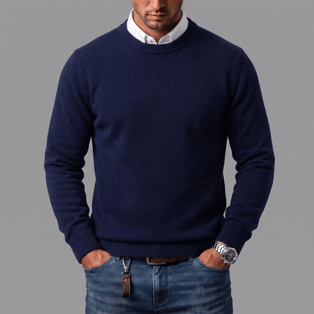 Man draagt de Denzel trui in marineblauw over een wit overhemd, voor een casual en toch verfijnde uitstraling.