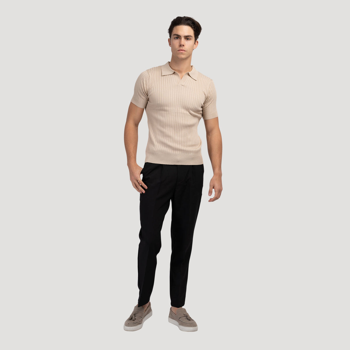 Beige geribbeld poloshirt, op een mannequin, toont de klassieke pasvorm en proporties van het shirt.