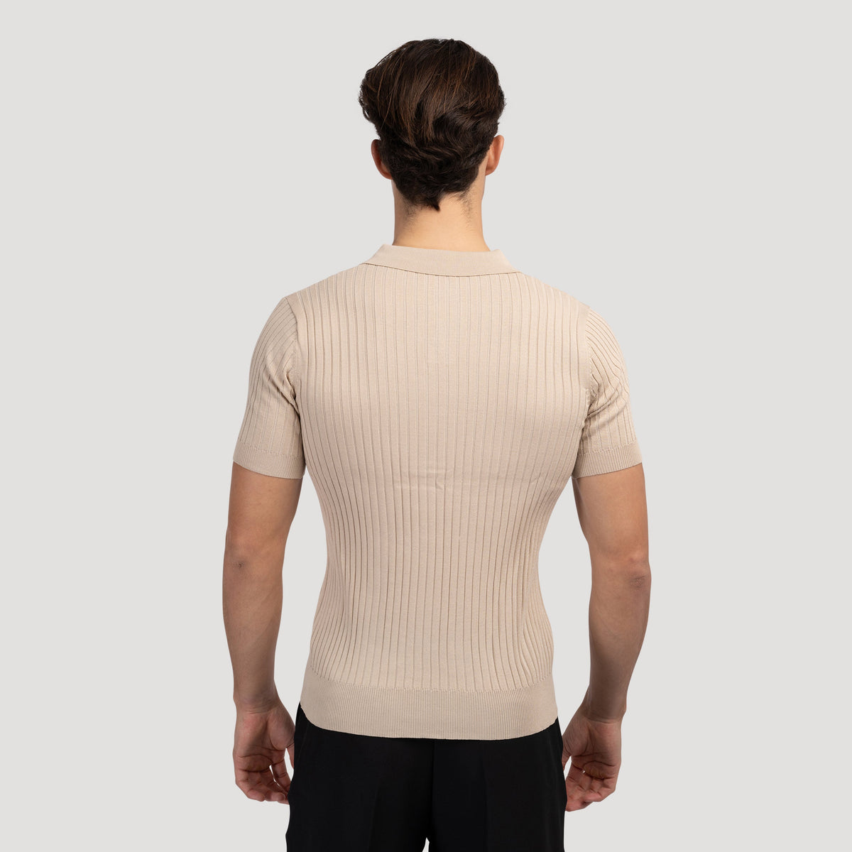 Zwart V-hals poloshirt, close-up van de onderboord en het subtiele stikwerk, hoogwaardige afwerking.