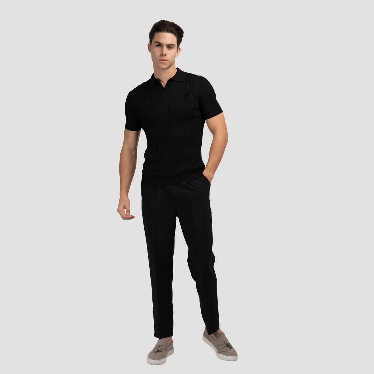Zwart geribbeld poloshirt, op een houten oppervlak, natuurlijke en rustieke setting voor het shirt.
