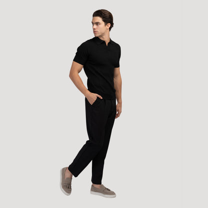 Model in het beige V-hals poloshirt, lopend door een park, beweging en comfort in de buitenlucht.