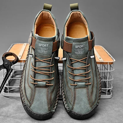 Zijaanzicht van de bruine leren herensneakers met de kenmerkende handgemaakte stiksels.
