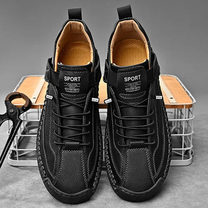 De zwarte leren herensneakers op een houten vloer, voor een klassieke presentatie.