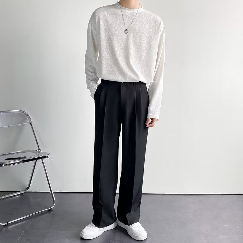 Een man draagt de zwarte getailleerde pantalon in een formele setting, staand met een gestreken overhemd.