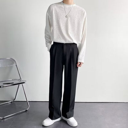 Een man draagt de zwarte getailleerde pantalon in een formele setting, staand met een gestreken overhemd.