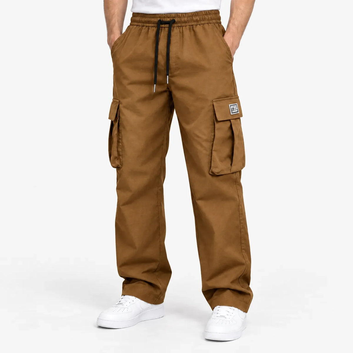 Man met de bruine cargobroek heren tijdens een stedelijke wandeling, perfect voor weekenduitjes.