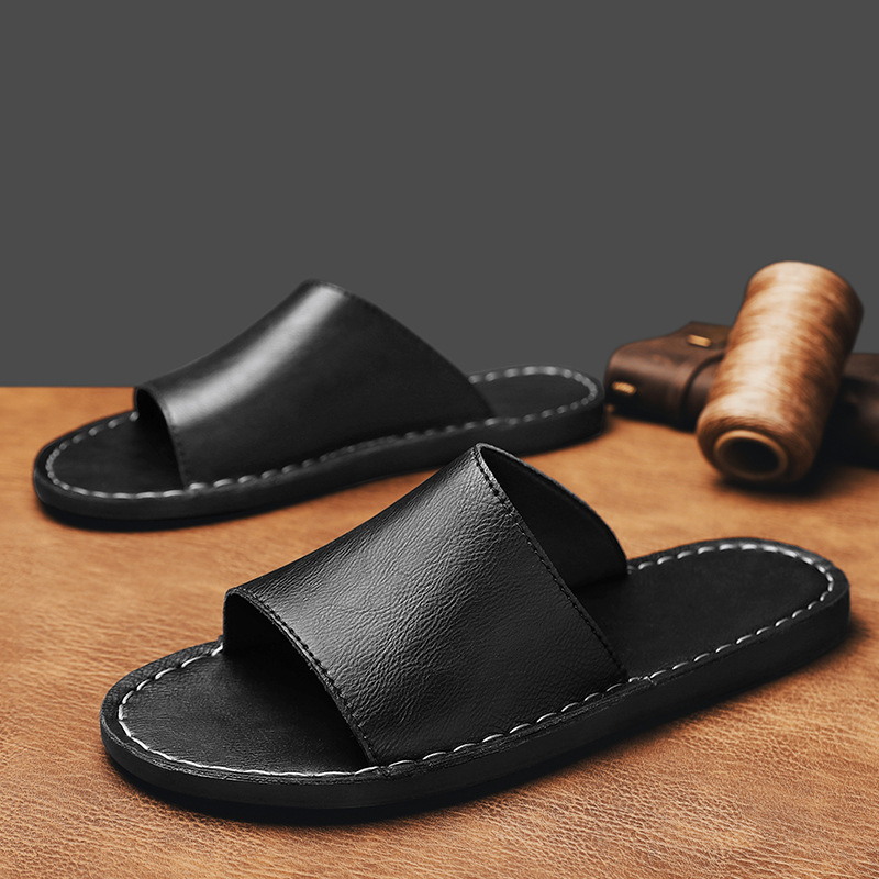Achterkant van de zwarte leren sandalen, met nadruk op de stevige zool en hielondersteuning.