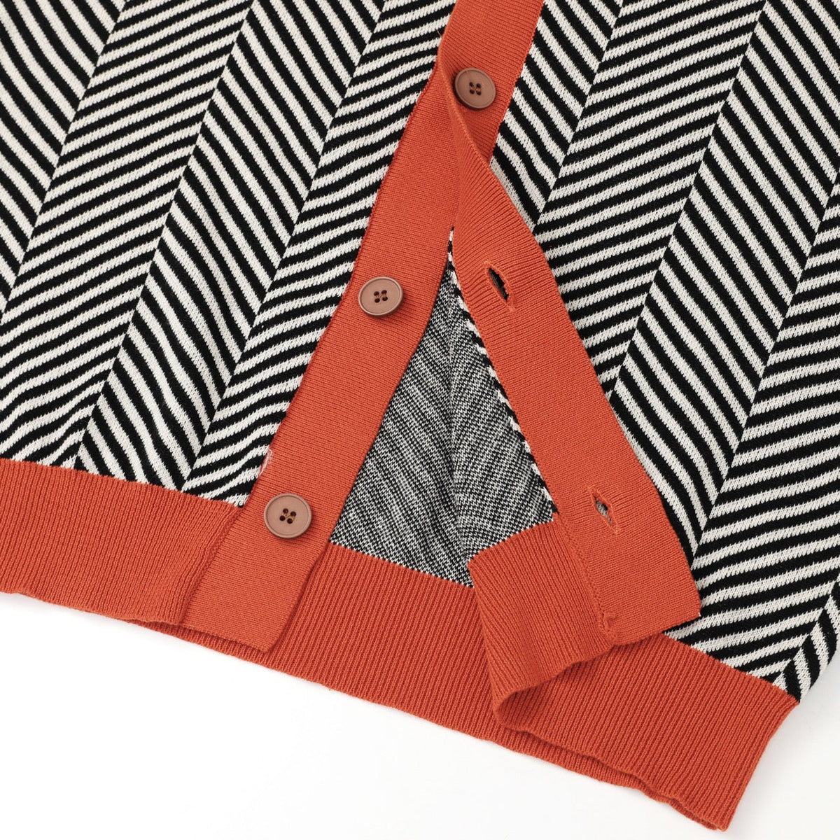 De zwarte cardigan subtiel gecombineerd met accessoires, benadrukt de tijdloze en makkelijk te stylen aard van het kledingstuk.
