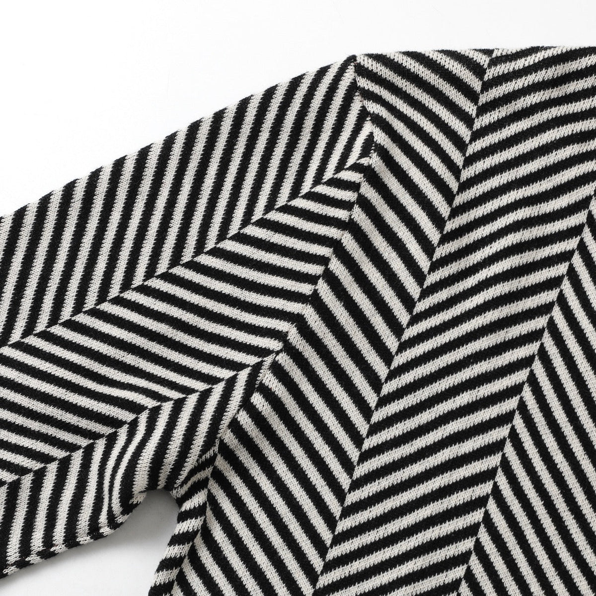 Detailopname van het unieke jacquard breipatroon van de cardigan, met nadruk op de textuur en de fijne afwerking.