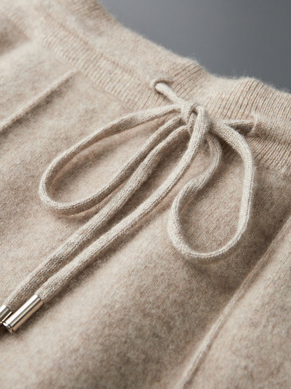 Luxe navy blauwe Merino wollen sweater, gedrapeerd over een stoel in een minimalistische setting.