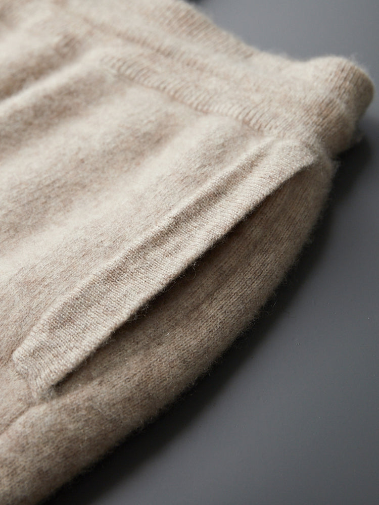 Model lachend, draagt de diepblauwe Merino wollen sweater in een ontspannen, casual setting.