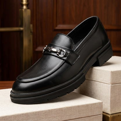 Stijlvolle man die de zwarte leren loafers heren draagt in een kantooromgeving, straalt professionaliteit en comfort uit.