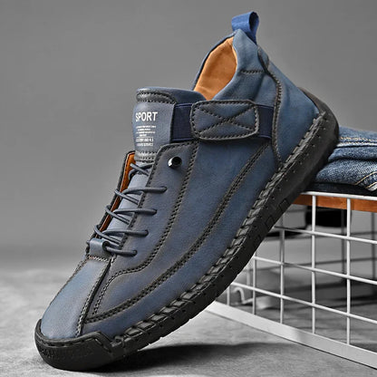 Detailopname van de veters en de gepolsterde schacht van de crème leren herensneakers.
