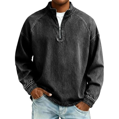 Close-up van de quarter-zip sluiting op een zwarte herentrui, met de opstaande kraag duidelijk zichtbaar.