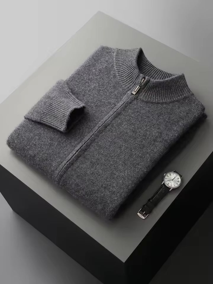Vier opgevouwen Merino wollen sweaters in diverse kleuren, netjes gestapeld op een plank.