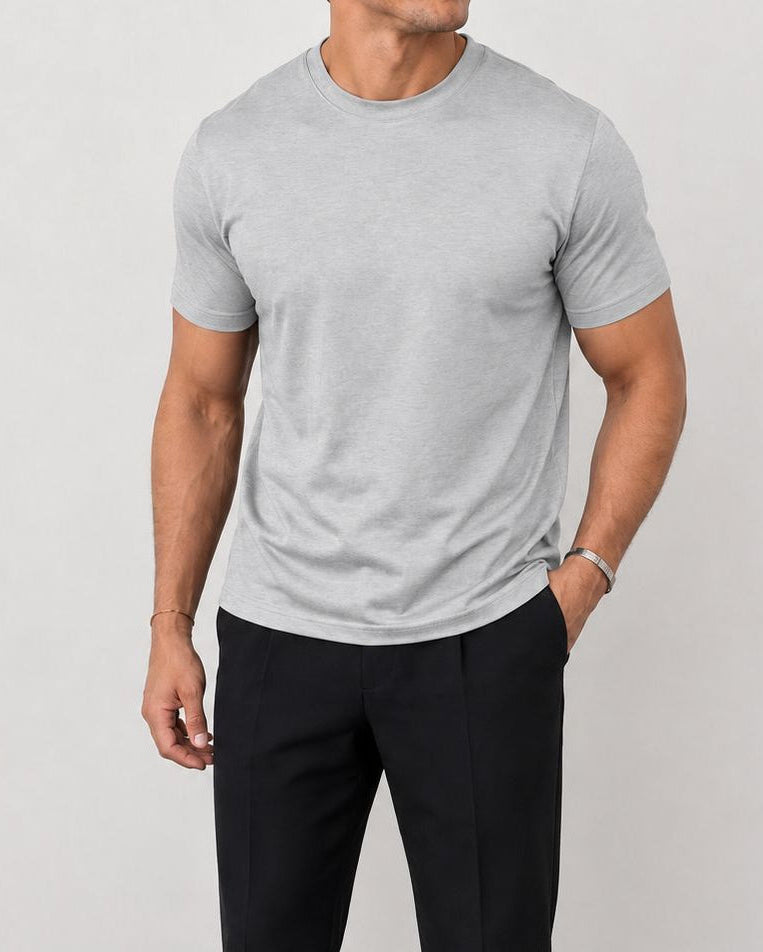 Man die een grijs Heren T-shirt combineert met een open jas, wat de veelzijdigheid voor gelaagde outfits illustreert.