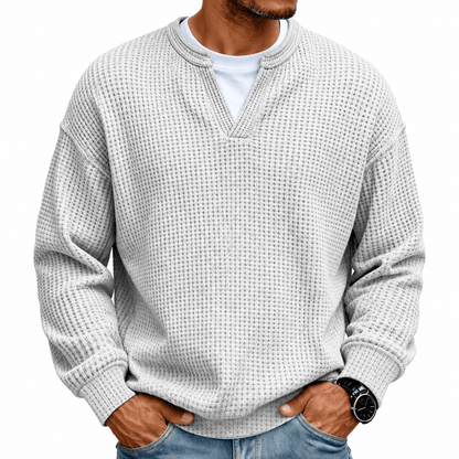 Close-up van de kraag en halslijn van de paarse wafelgebreide heren sweater, voor een gedetailleerde blik.