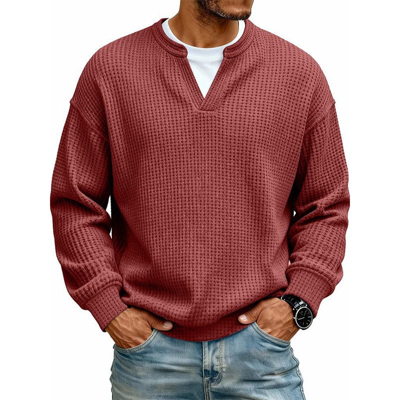 Een man ontspant in de groene Merijn wafelgebreide sweater, zittend, wat het comfort en de pasvorm benadrukt.