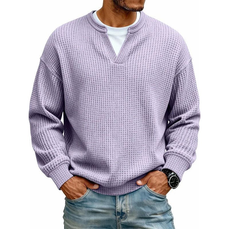 Een man in een casual setting, draagt de grijze wafelgebreide trui over een T-shirt, ideaal voor laagjes.