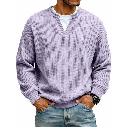 Een man in een casual setting, draagt de grijze wafelgebreide trui over een T-shirt, ideaal voor laagjes.