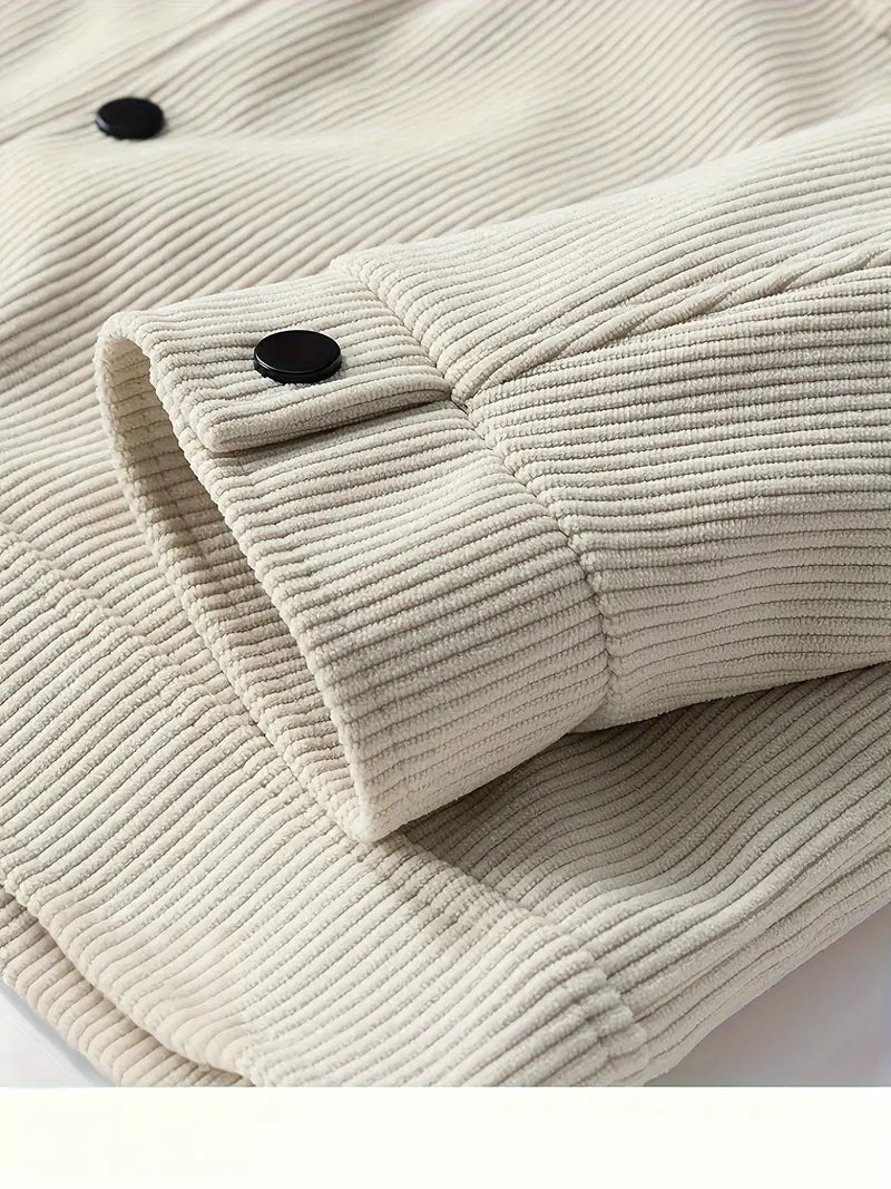 De groene corduroy herenjas liggend op een vlakke ondergrond, perfect gepresenteerd om de stof en kleur te laten zien.