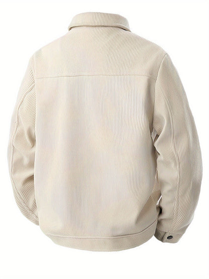 Een man leunt casual tegen een muur, dragend de beige corduroy herenjas, die zijn ontspannen maar stijlvolle uitstraling benadrukt.