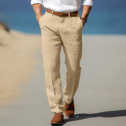 Een man draagt de witte linnen herenbroek in een ontspannen zomerse setting, elegant gestyled.
