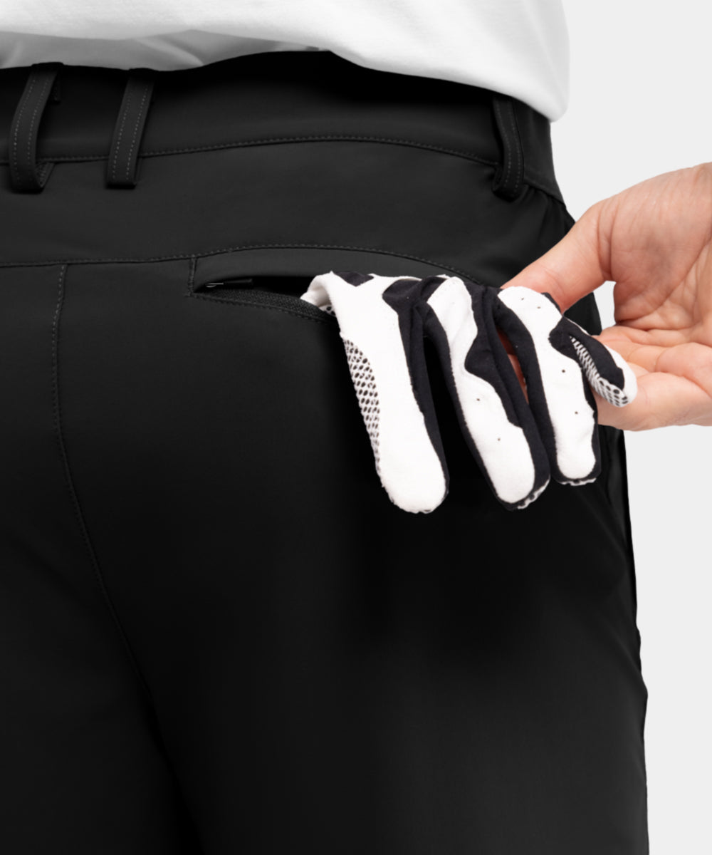 Model draagt de kameelkleurige Arthur shorts op een terras, wat de geschiktheid voor vrijetijd toont.