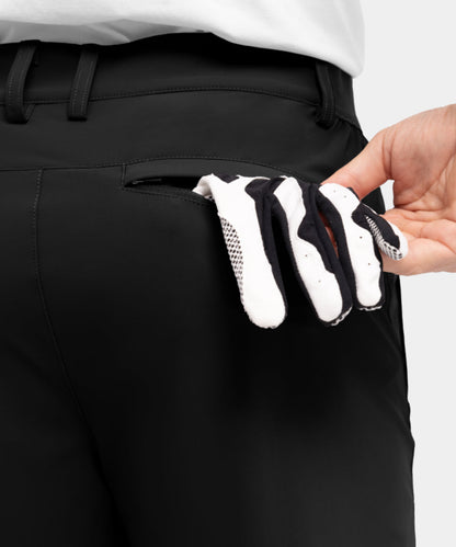 Model draagt de kameelkleurige Arthur shorts op een terras, wat de geschiktheid voor vrijetijd toont.