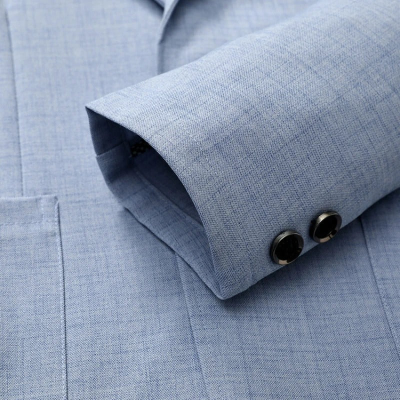 Detailopname van de revers en de knoopsluiting van de grijze herenblazer, met de klassieke, tijdloze uitstraling.