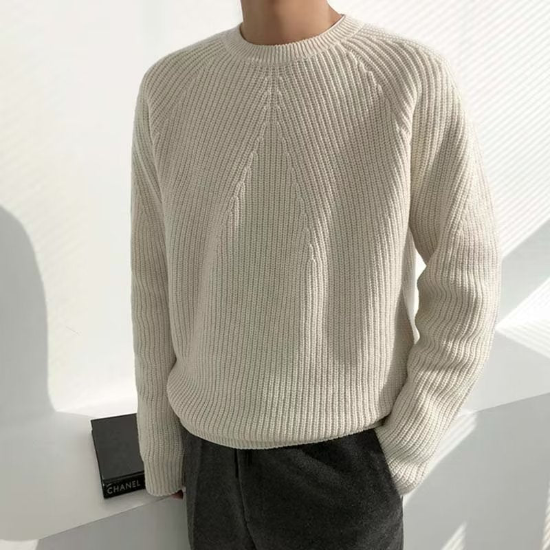Een man draagt de witte Caspar sweater, staand in een ontspannen, casual pose.