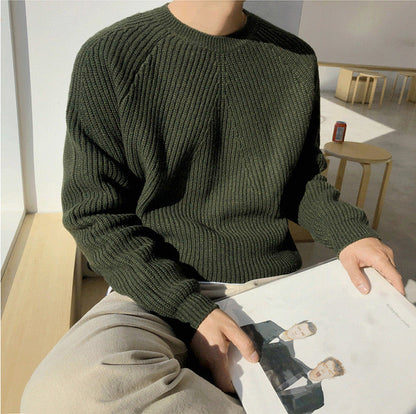 De witte heren sweater op een platte ondergrond, met aandacht voor de raglanmouwaanhechting.