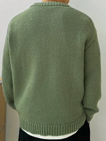 Detail van de mouwboorden en de onderkant van de marineblauwe heren sweater, met aandacht voor de afwerking.