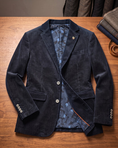 Detailopname van de twee-knoops sluiting op de corduroy jas, met aandacht voor de afwerking.
