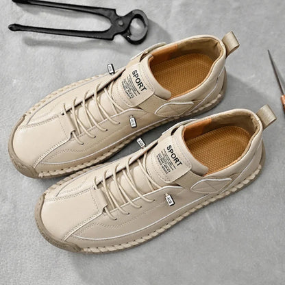 De grijze leren herensneakers op een lichte ondergrond, toont de veelzijdigheid.