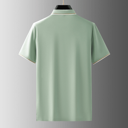 Overzicht van een man die een poloshirt draagt in een lichte, natuurlijke omgeving.