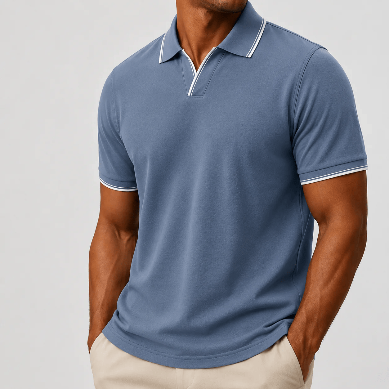 Zijaanzicht van de man in het blauwe poloshirt, toont de pasvorm en de stofkwaliteit.