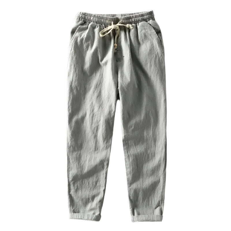 Close-up van de textuur en de tailleband van de grijze linnen trousers, gedetailleerd en elegant.